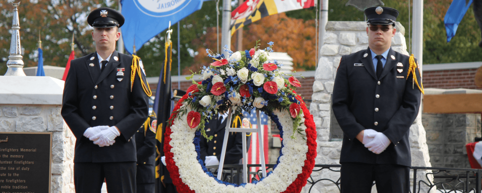 Image of law enforcement standing by memorial wreath