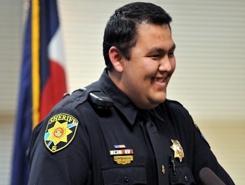 A smiling man in a police officer uniform