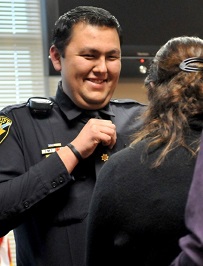 A smiling man in a police officer uniform