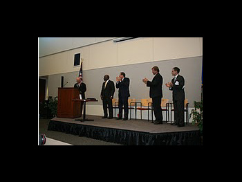 A group of people standing on a stage at the Badge of Bravery award ceremony