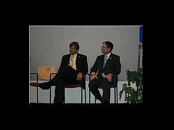 Two people sitting in chairs at the Badge of Bravery award ceremony