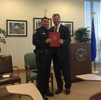 Two people standing together at the Badge of Bravery awards ceremony and smiling at the camera