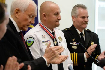 A group of people applauding at the Badge of Bravery awards ceremony