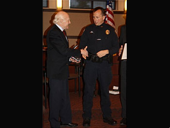 Two people shaking hands at the Badge of Bravery awards ceremony