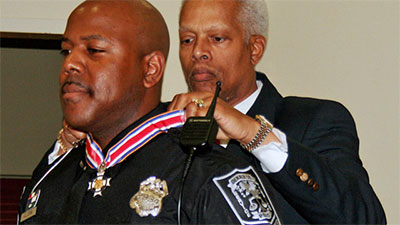 An officer being presented with a Badge of Bravery award
