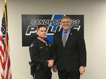 Two people standing together at the Badge of Bravery awards ceremony and smiling at the camera