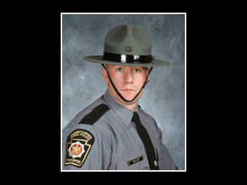 a head and shoulders view of a man in a state trooper uniform facing the camera