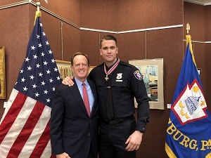 Two people standing together at the Badge of Bravery awards ceremony and smiling at the camera
