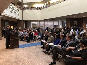 A man giving a speech to a crowd of people at the Badge of Bravery awards ceremony