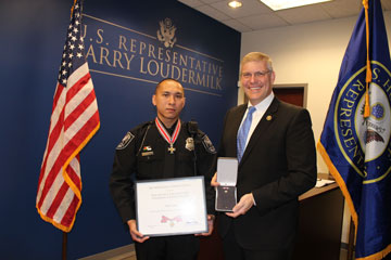 Two people standing together at the Badge of Bravery awards ceremony and smiling at the camera