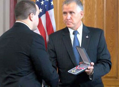 A man being presented with a Badge of Bravery award
