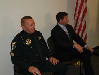 Two men sitting in chairs at the Badge of Bravery awards ceremony