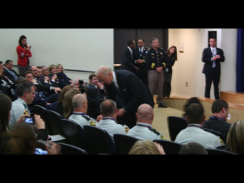 A crowd of people at the Medal of Valor ceremony. Some are seated and some are standing around the edges.