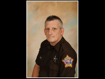 a head and shoulders portrait of man in a sheriff uniform facing the camera