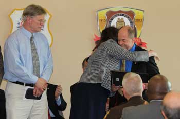 A woman hugging a man at the Badge of Bravery award ceremony