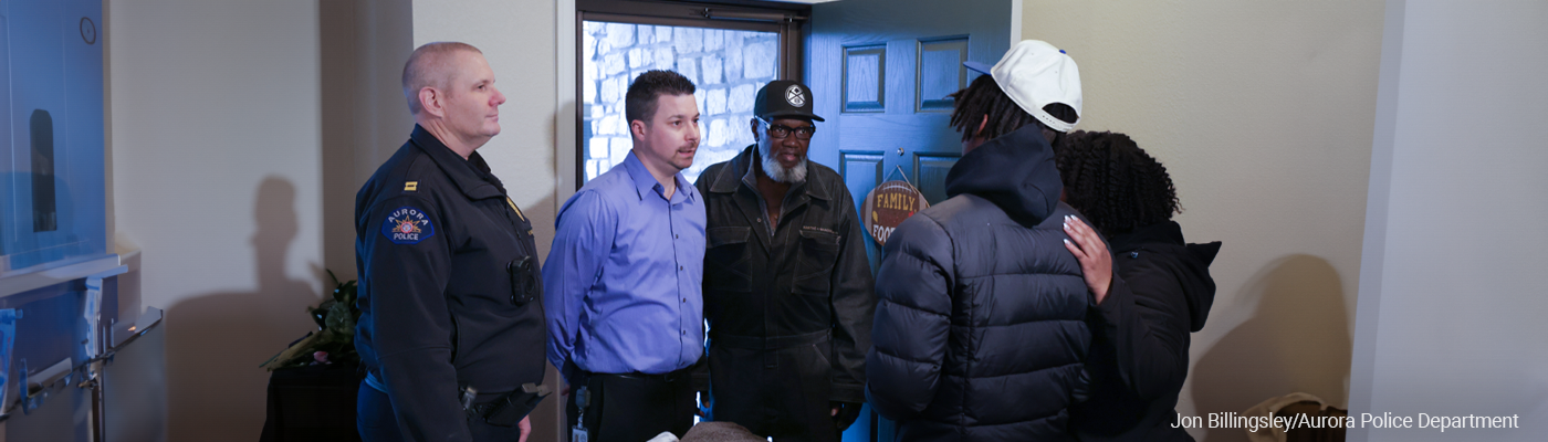 Aurora Police Department Captain Mike Hanifin, Aurora Youth Violence Prevention Program Manager Joseph DeHerrera and James Thomas of The Road Called Strate participate in a mock custom notification, a main outreach strategy of the Aurora Standing Against Violence Every Day (SAVE) initiative.