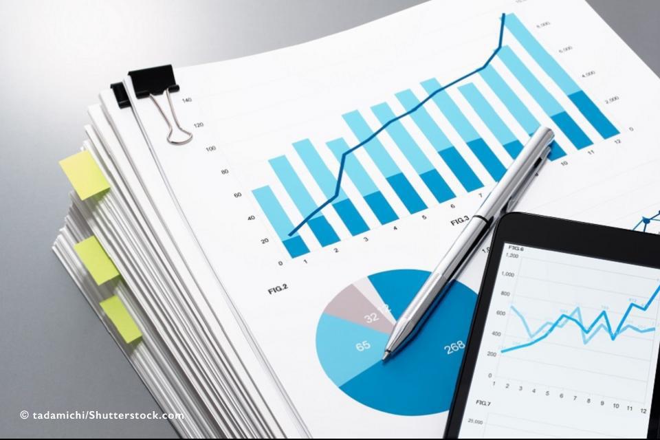 Pile of papers with charts and graphs and smart phone