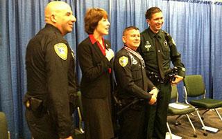 A group of four people standing together in a row at the Badge of Bravery awards ceremony