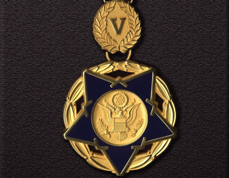 a Medal of Valor award pendant against a dark background