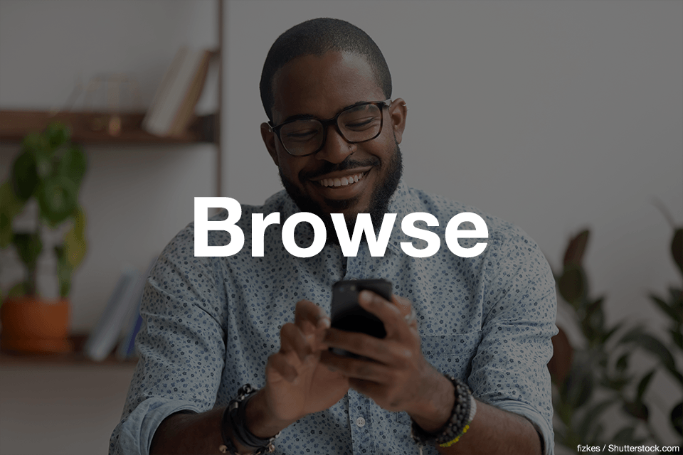 African American man smiling and scrolling on his phone